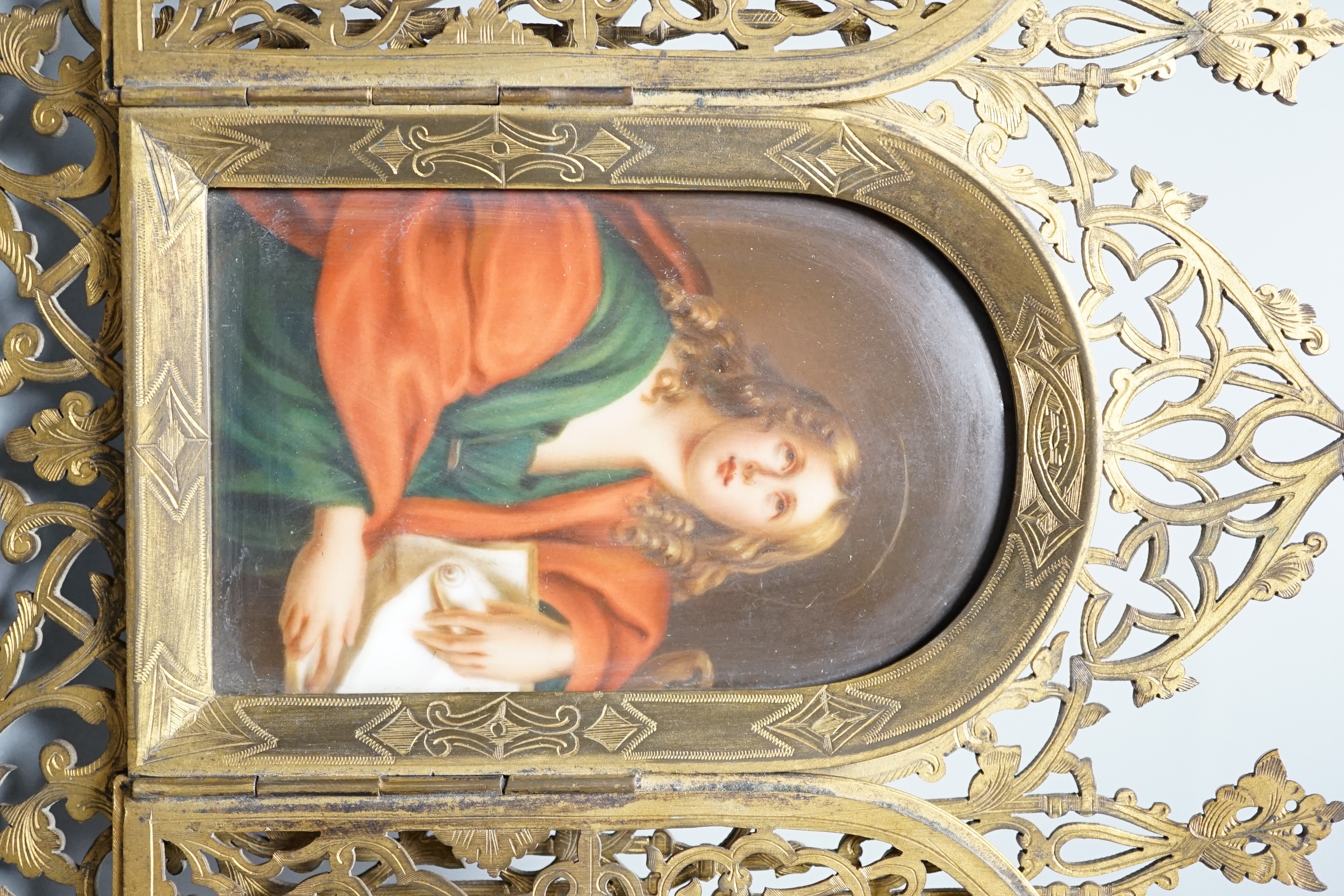 A Continental painted porcelain icon plaque in three fold pierced brass frame by Marion, London, 19cm tall